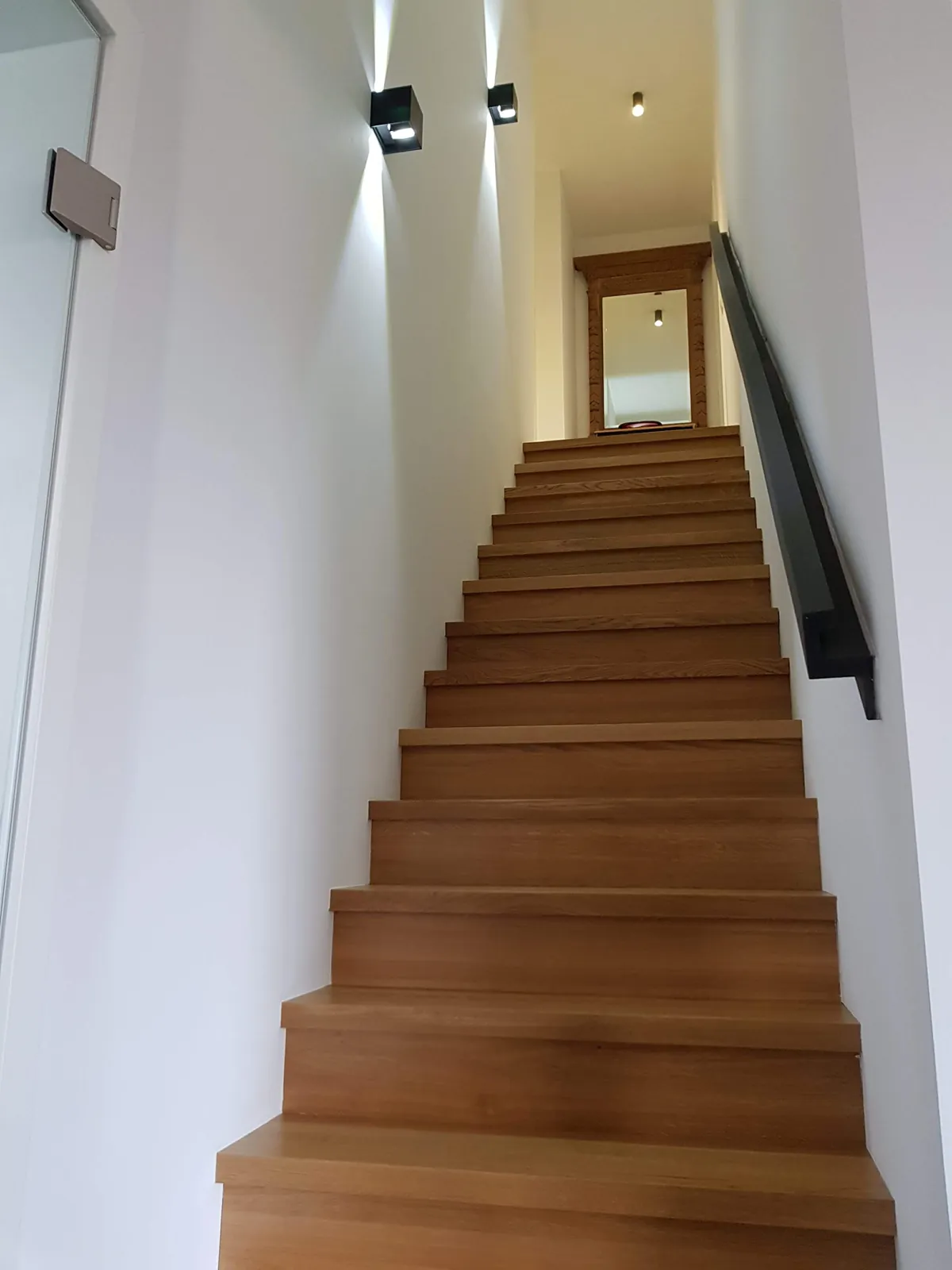 Escalier droit en bois avec main courante noire et appliques murales