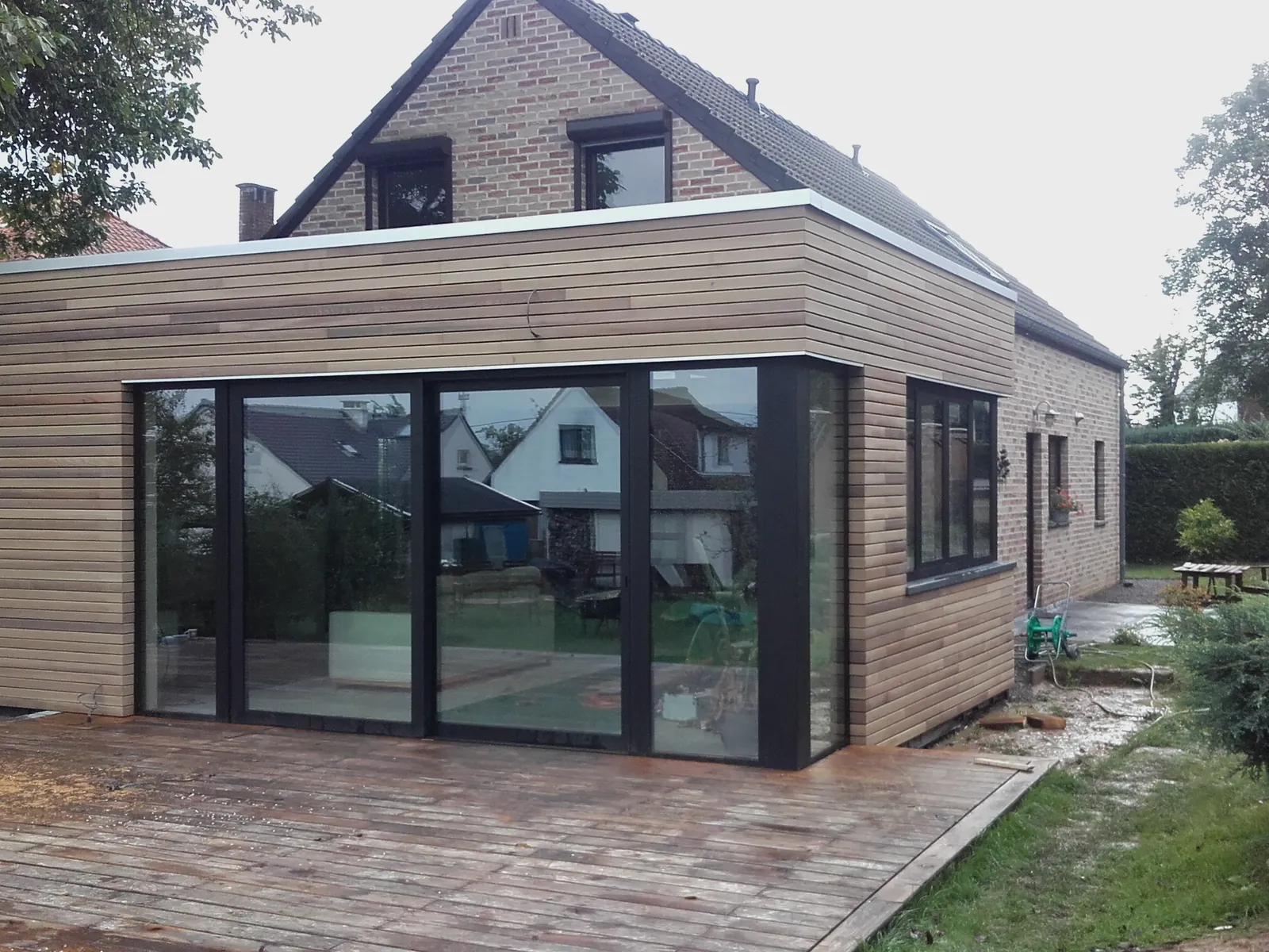 Extension bardée de lattes avec grande baie coulissante et terrasse