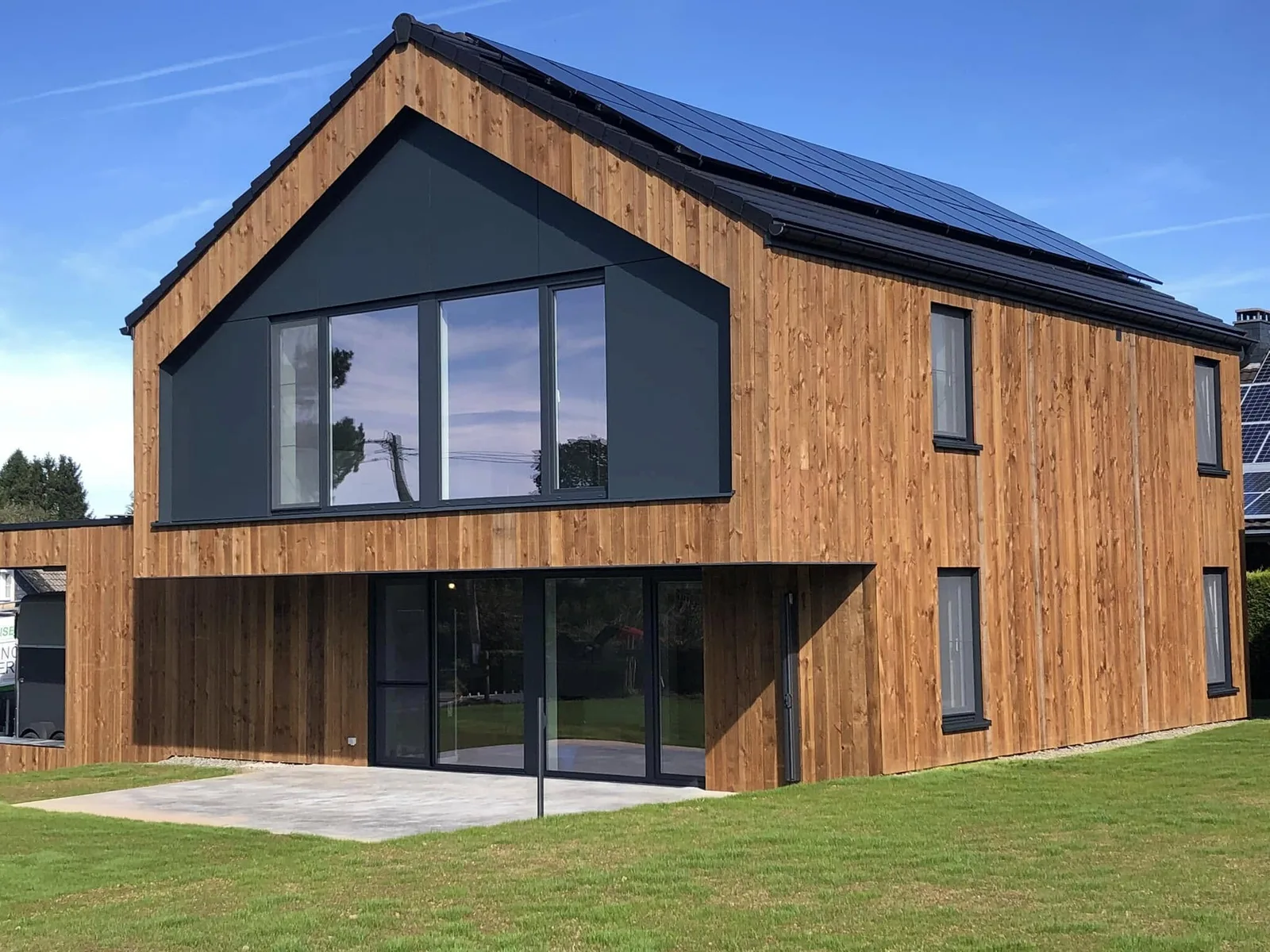 Maison en ossature bois avec bardage et pignon vitré, réalisée par Menuiserie Mertens