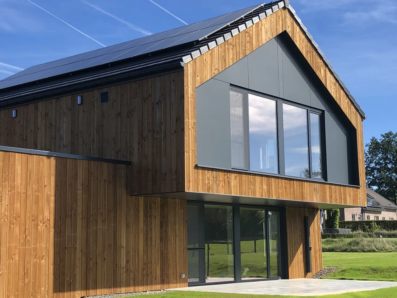 Maison en ossature bois à bardage vertical et grand pignon vitré