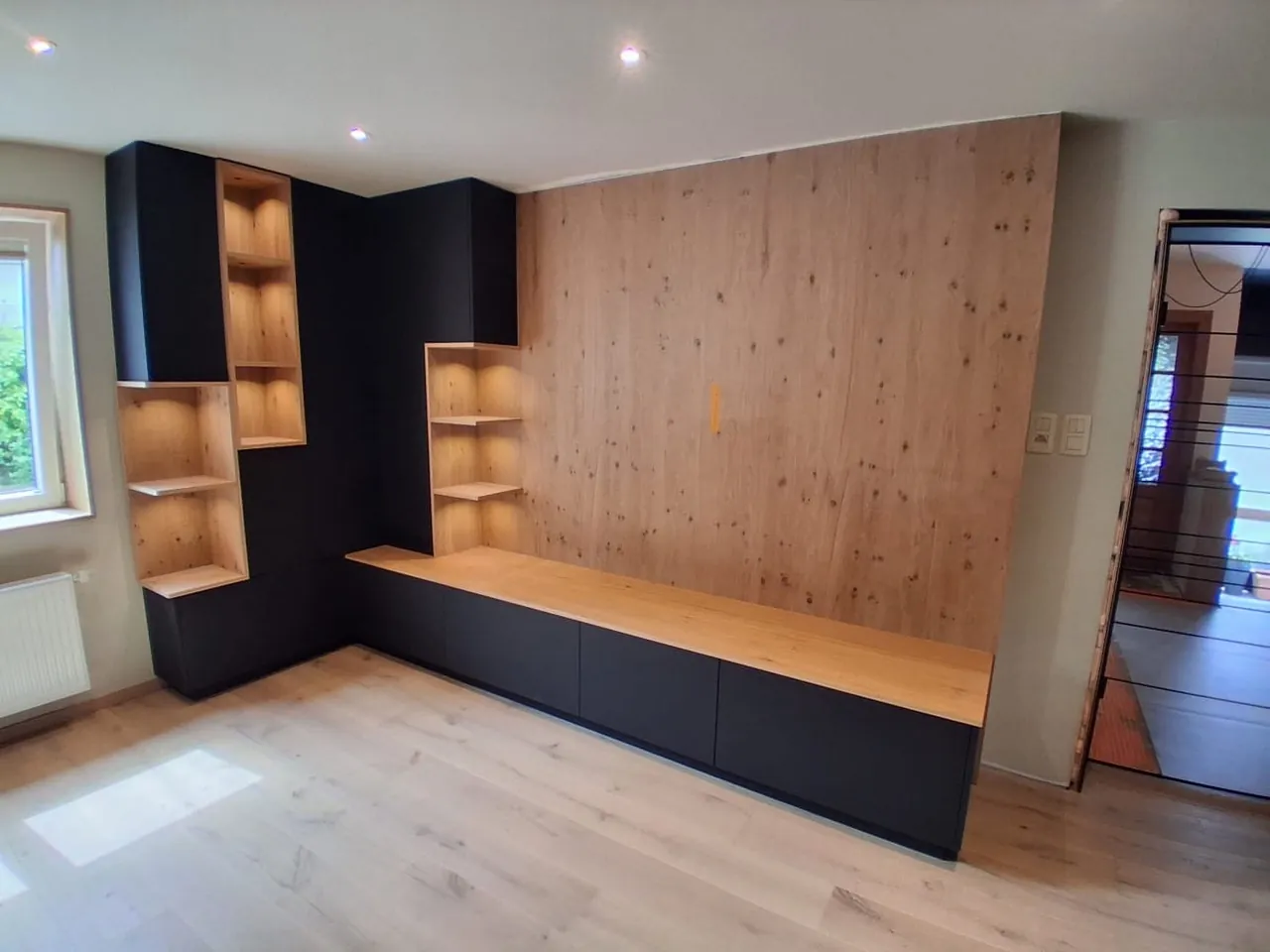Meuble TV en angle, colonnes noires et long plateau en bois