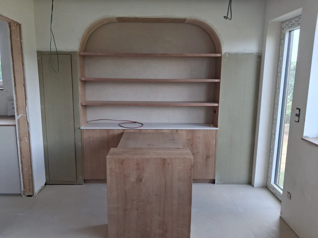 Niche en arche avec étagères, meuble bas et îlot en cours de pose