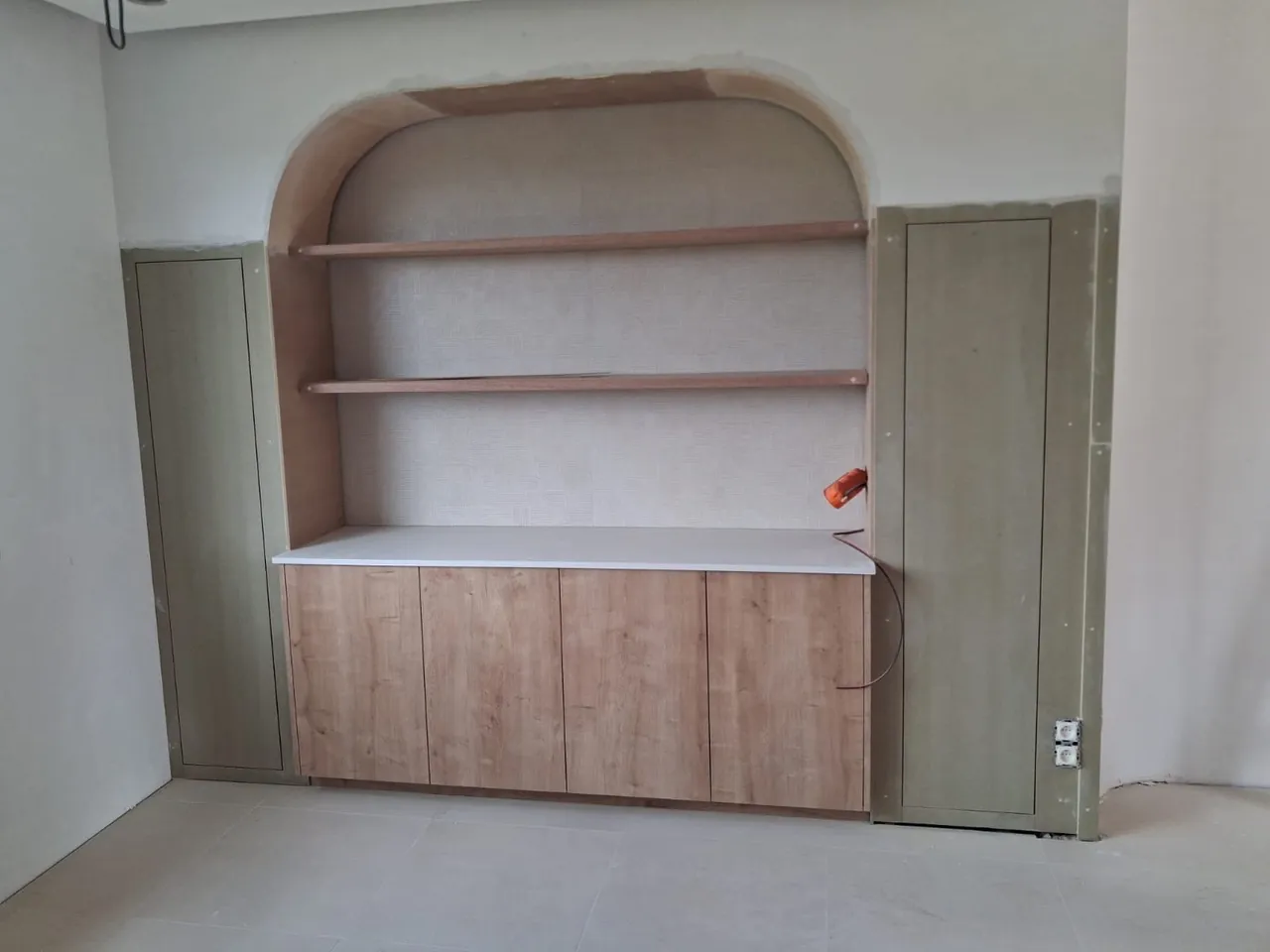 Niche en arche à étagères au-dessus d'un meuble bas en bois